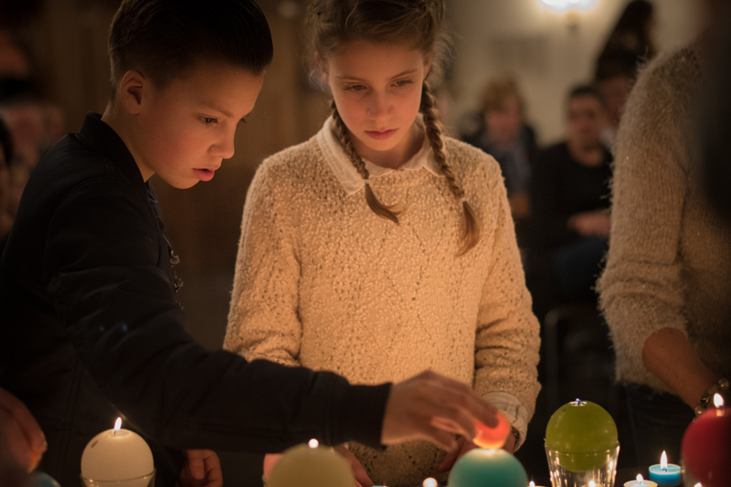 Kleinkinderen steken kaarsjes aan