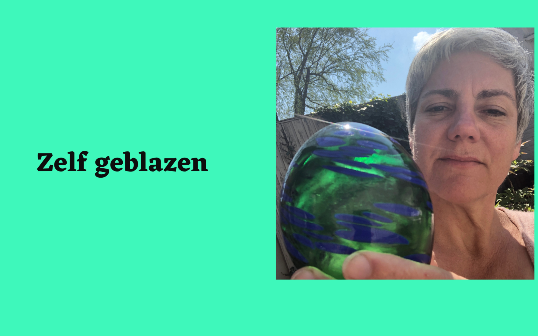 Boukje houdt een glazen kunstwerk in haar hand die de kleuren groen en blauw tonen